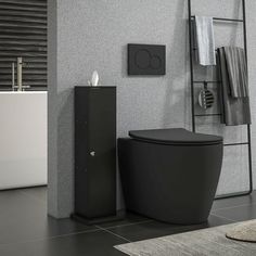 a black toilet sitting next to a white sink in a room with grey walls and flooring