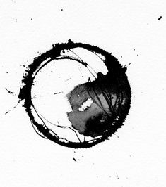 a black and white photo of a circle with some paint splatters on it