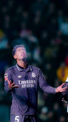 a soccer player holding his hands out in the air