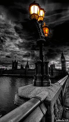 a street light sitting on the side of a bridge next to a body of water