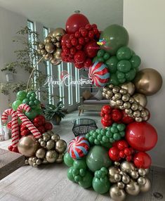 an arch made out of balloons and candy canes in the shape of a christmas tree