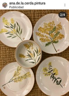 four plates with yellow flowers painted on them