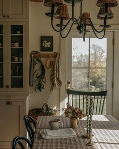 a dining room table with chairs and a potted plant on top of the table