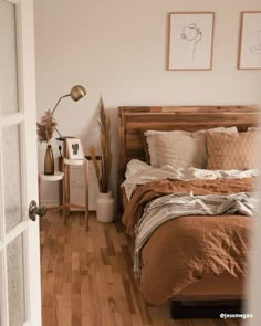 a bed room with a neatly made bed and wooden floors