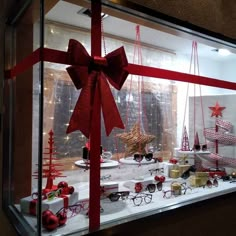 a display case filled with lots of christmas decorations and glasses in front of a window