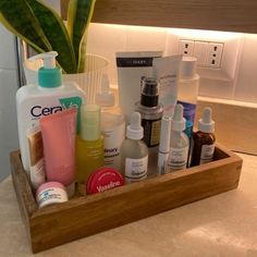 a wooden container filled with different types of skin care products on top of a counter