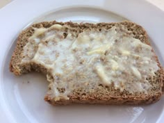 a piece of bread with white sauce on it sitting on top of a white plate