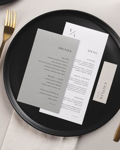 a black plate topped with a menu and silverware