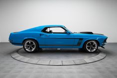 a blue mustang muscle car sitting on top of a circle