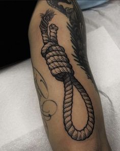 a man with a tattoo on his arm has a rope wrapped around the end of it