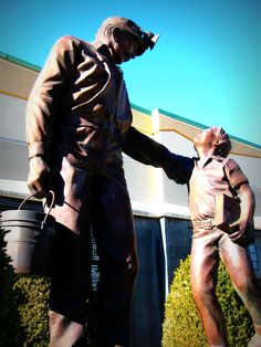 a statue of a man holding the hand of another man