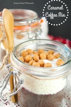 a jar filled with coffee and nuts on top of a table next to spoons