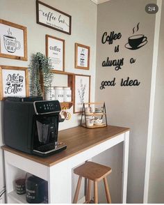 there is a coffee maker on the counter in this room with framed pictures above it