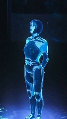 a man is standing in the dark with his hands on his hips while wearing a futuristic suit