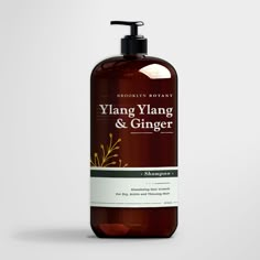 a bottle of ylang yang and ginger shampoo on a white background with an orange dropper