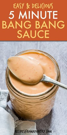 a jar filled with sauce on top of a table next to a spoon and napkin