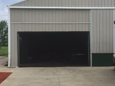 a white truck parked in front of a building with an open garage door on the side