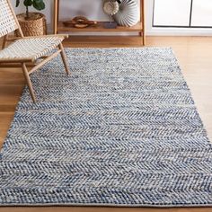 a living room area with a chair, rug and bookshelf