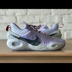 a pair of shoes that are on top of a wooden table with a brick wall in the background