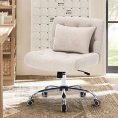 a white office chair sitting on top of a wooden floor next to a desk with a calendar on the wall