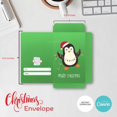 a green christmas envelope with a penguin on it next to a keyboard and cup of coffee