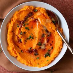 a white bowl filled with mashed potatoes topped with parsley