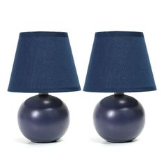 two blue lamps sitting next to each other on a white surface with a dark blue shade