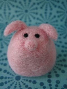 a small pink pig sitting on top of a table