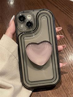 a woman's hand holding an iphone case with a heart on it