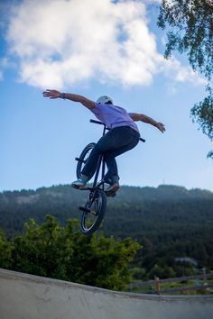 a man riding a bike up the side of a ramp