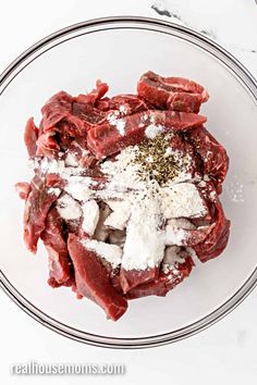 raw meat in a glass bowl with seasoning and salt