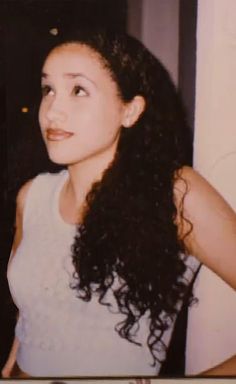 an old photo of a woman with long curly hair