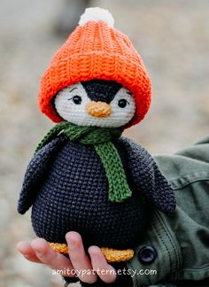 a knitted penguin with an orange hat and scarf