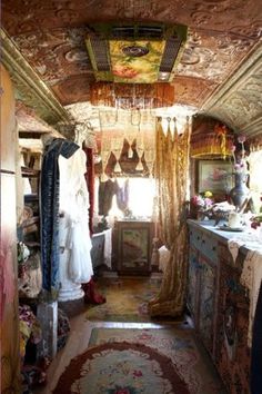 an old fashion store with lots of clothes hanging from the ceiling and rugs on the floor