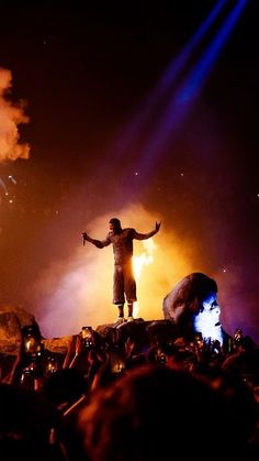 a man standing on top of a rock in front of a crowd