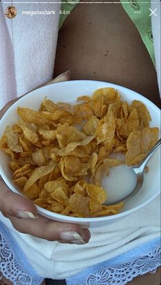 a person holding a bowl of chips and yogurt