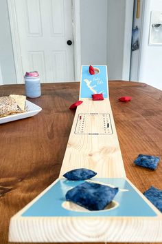 a wooden table topped with blue and red pieces of paper sitting on top of it