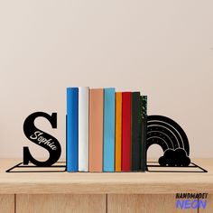 there is a bookend that has books on it with the letters s and w