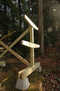 a wooden sculpture sitting in the middle of a forest