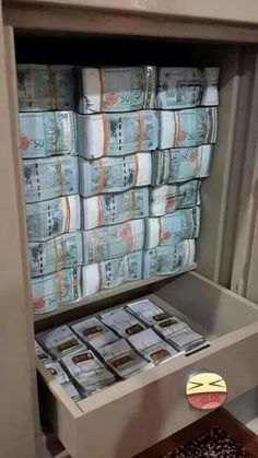 stacks of money sitting in a drawer with stickers on it