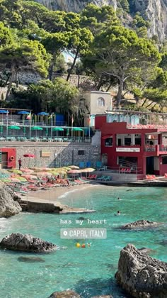 a red building sitting on top of a cliff next to the ocean