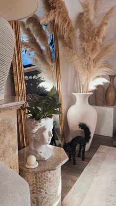 there is a vase with feathers in it and a mirror on the wall behind it