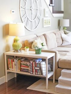 a living room filled with furniture and a large clock on the wall above it's bookshelf