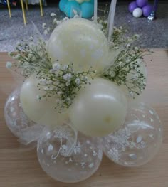 an arrangement of balloons and flowers on a table