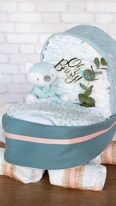 a baby's gift basket sitting on top of a wooden table next to a teddy bear