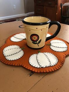 a coffee cup sitting on top of a wooden table next to an orange and white rug