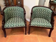 two chairs sitting next to each other on a tile floor