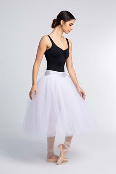 a woman wearing a white tulle skirt and black tank top