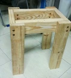 a wooden stool sitting on top of a white tile floor