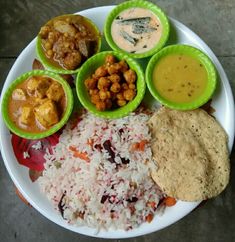 a white plate topped with different types of food on top of rice and sauces